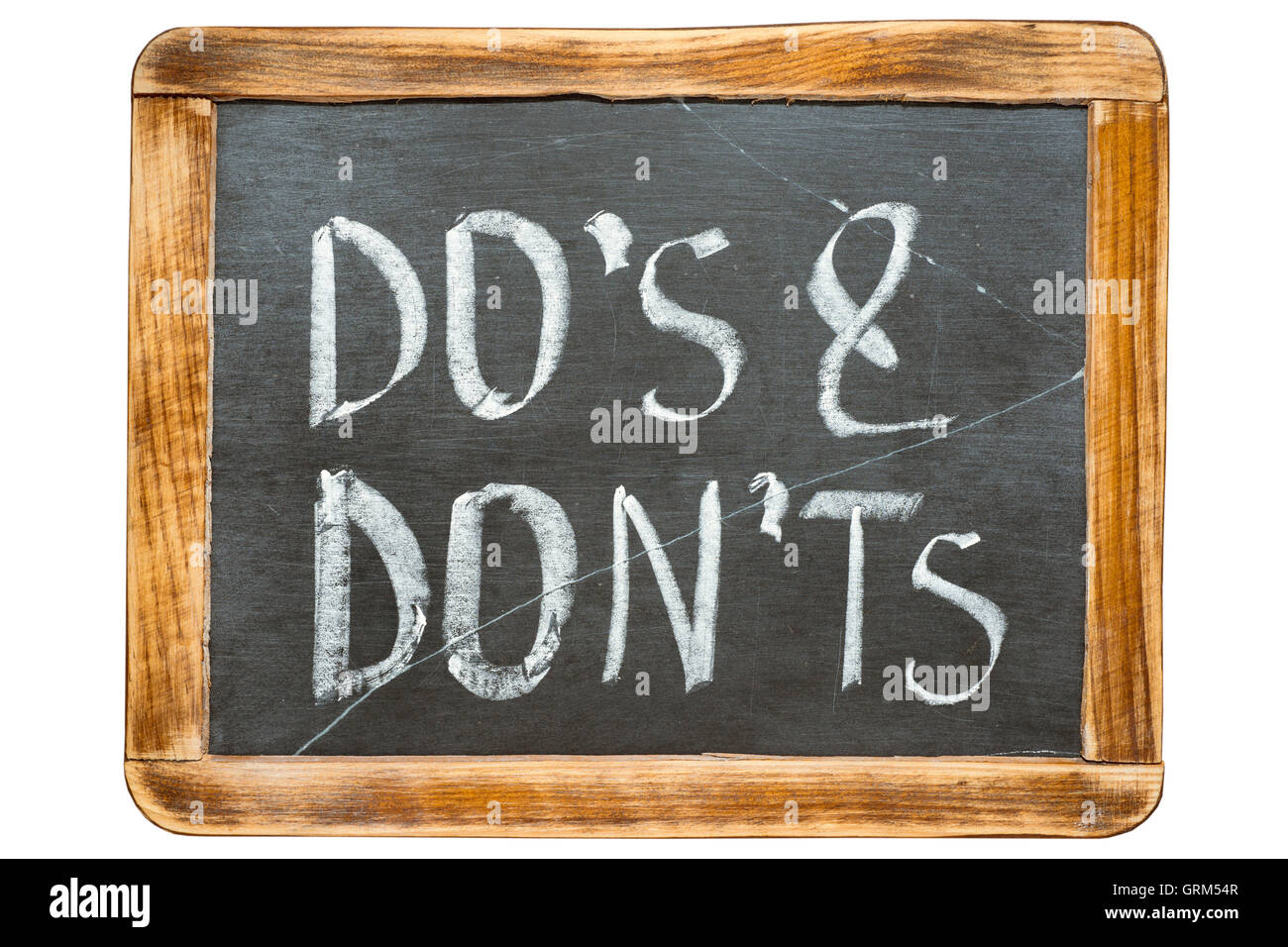do's and don't s phrase handwritten on vintage school slate board isolated on white Stock Photo