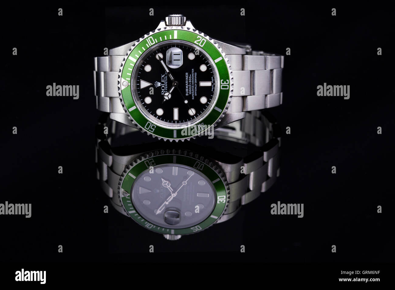 Green Rolex Submariner watch reflected on black background Stock Photo