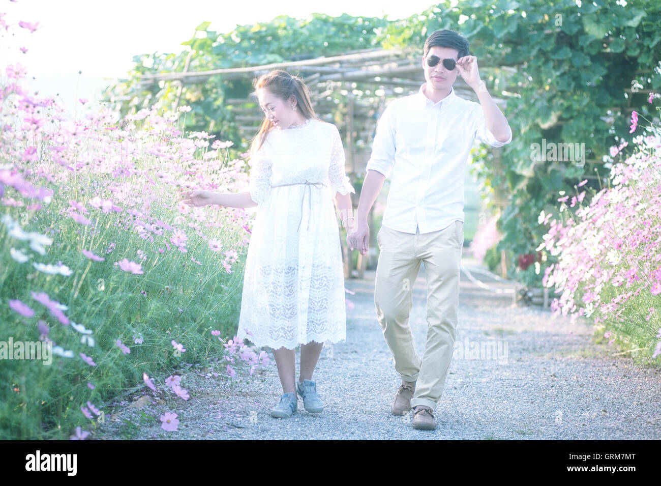 Young couple on among flowers. Both happy and smiling on Valentine's Day Stock Photo