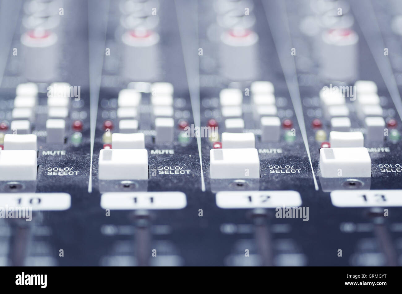 Closeup mixing faders and knobs as seen from above side angle, artistic