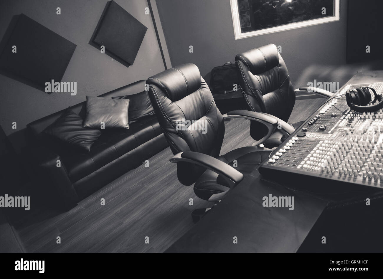 Classy professional recording studio setup, large desk with mixing console  and two chairs, window for vocal booth, sofa placed behind Stock Photo -  Alamy