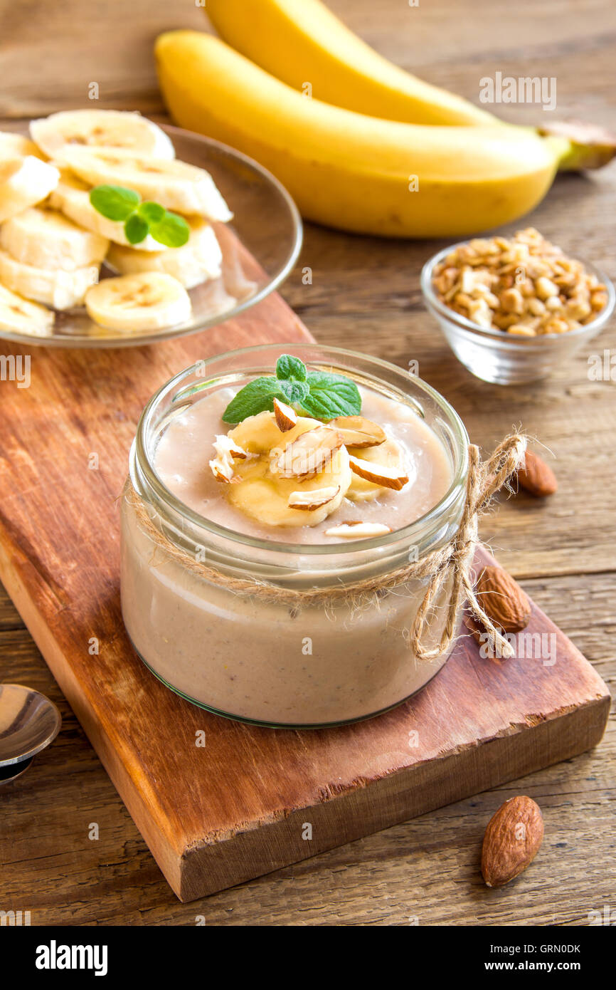 Banana mousse with almond and mint for healthy vegetarian dessert over rustic wooden background Stock Photo