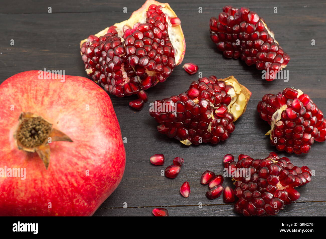 Juicy whole pomegranate and its seeds on white background Stock Photo