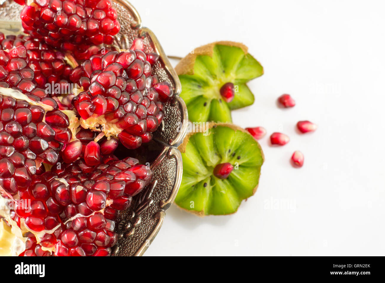 Juicy whole pomegranate and kiwi on white background Stock Photo