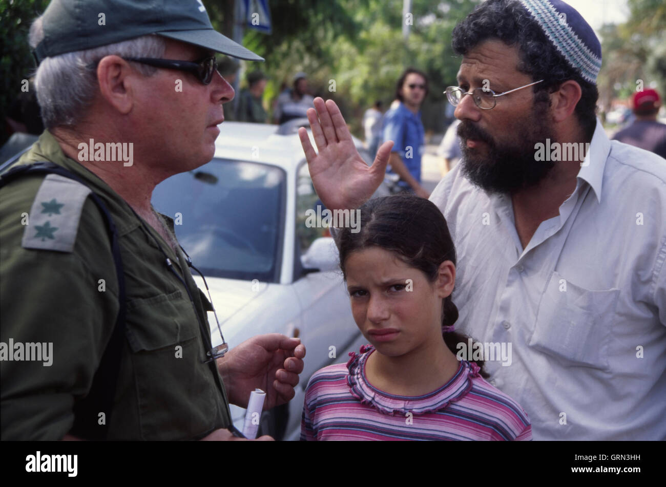 Gaza Disengagement, 2005. Lt. Col. David Amit, a reserve military historian, faces a settler and his daughter at the soon to be evacuated settlement of Neve Dekalim Stock Photo
