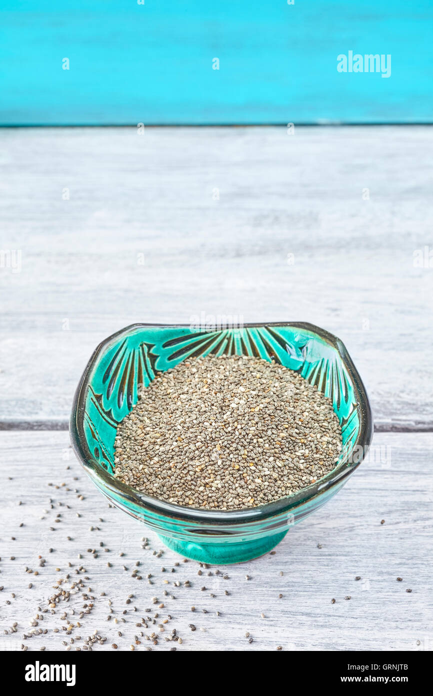 Chia seeds in a green bowl on rustic table, space for text. Stock Photo
