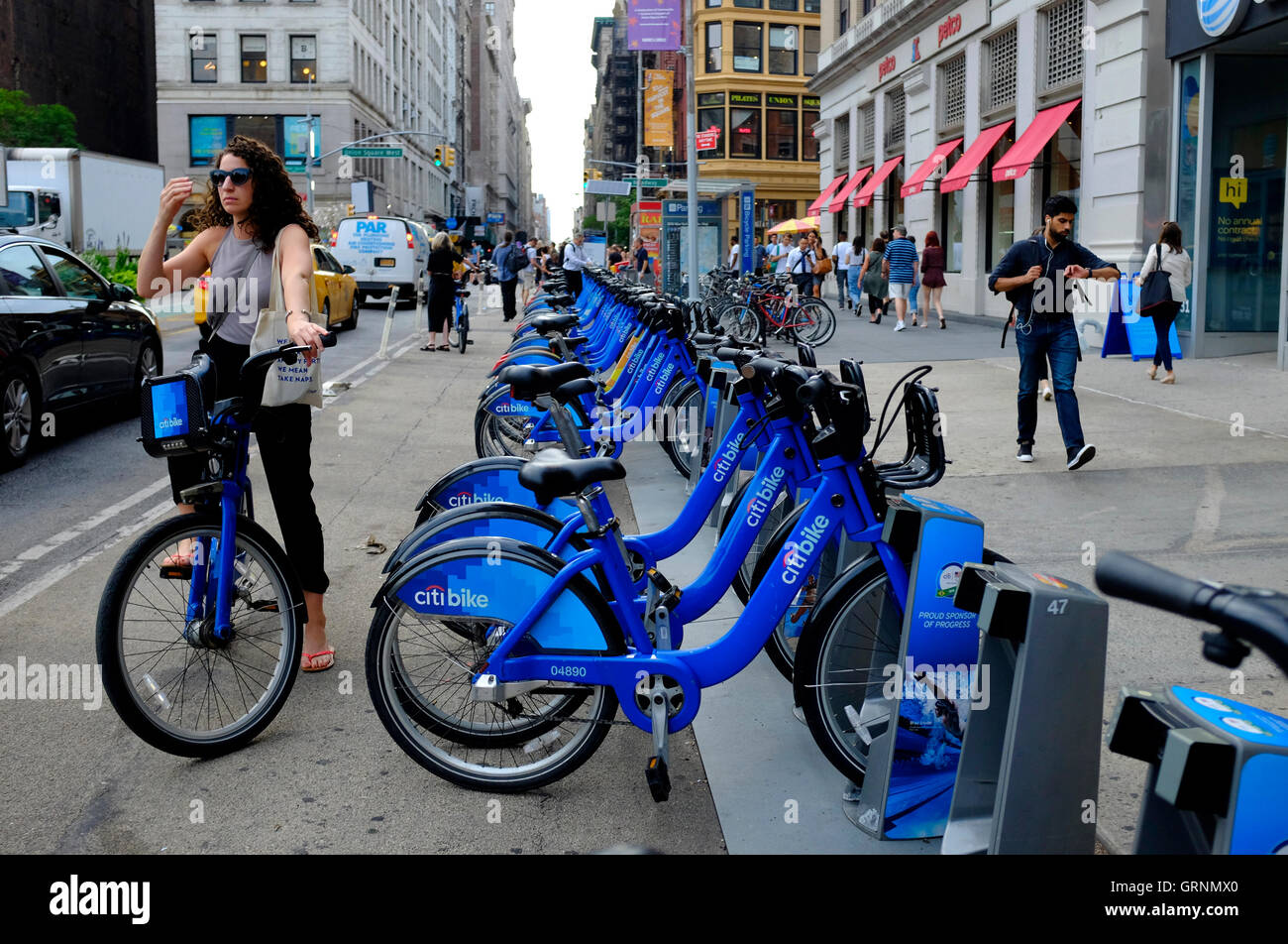 A female rider riding on a Citibike by a Citibike share station in Union Square.Manhattan.New York City,USA Stock Photo
