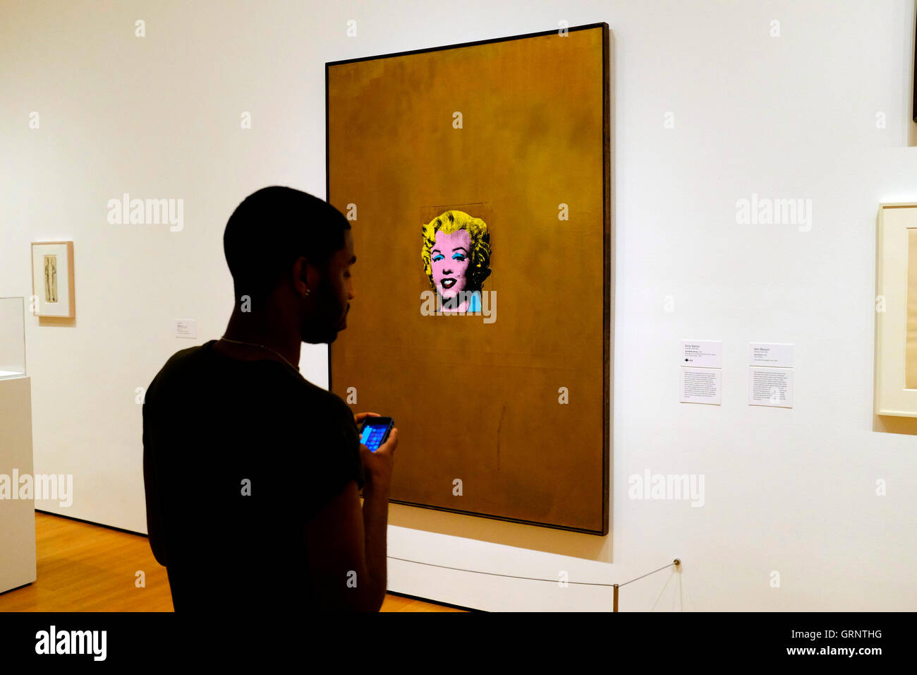 Visitor in front of Gold Marilyn Monroe by Andy Warhol at The Museum of Modern Art (MoMA).New York City,USA Stock Photo