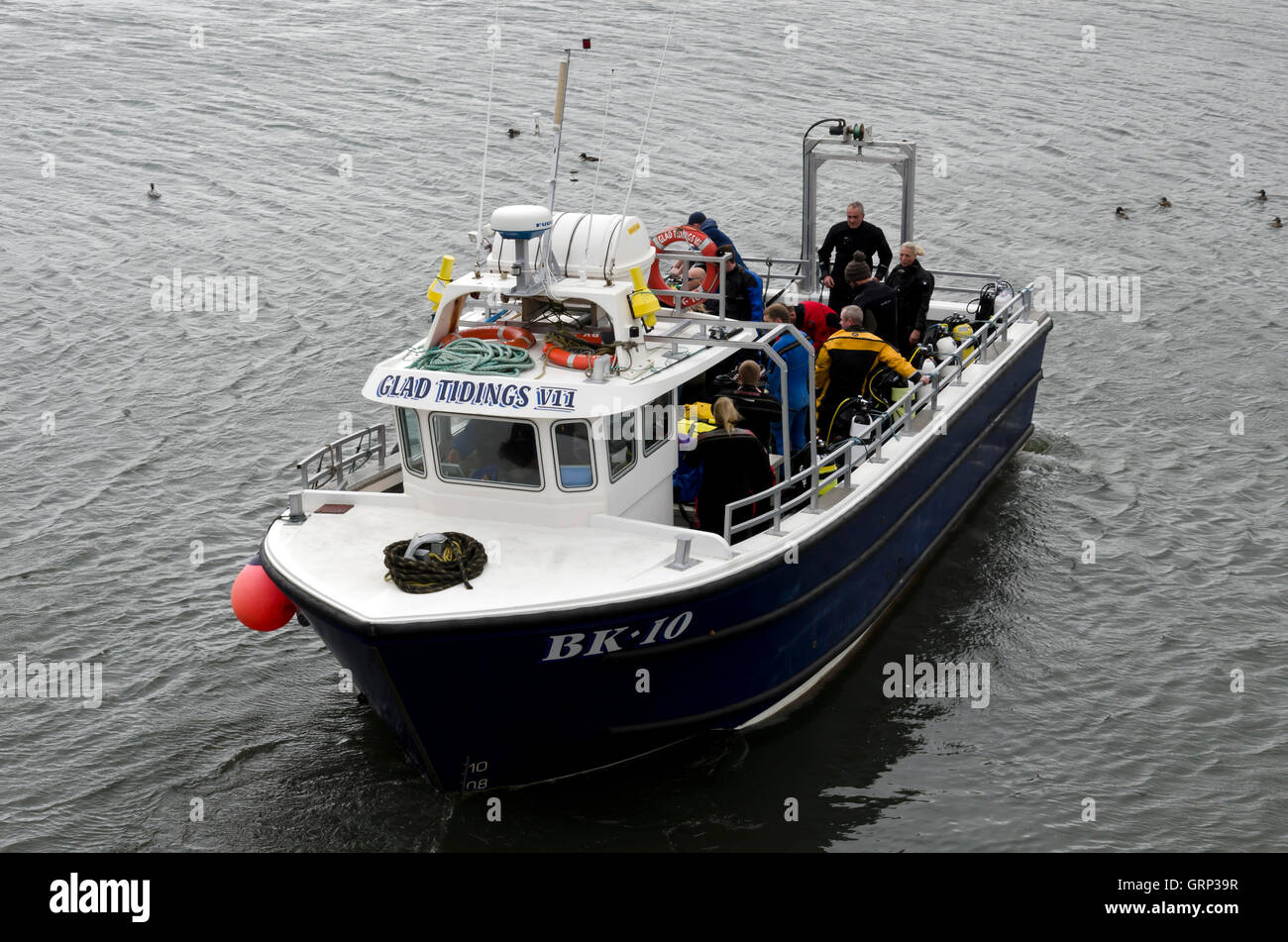 Boat carrying divers leaving Seahouses harbour in Northumberland, England. Stock Photo