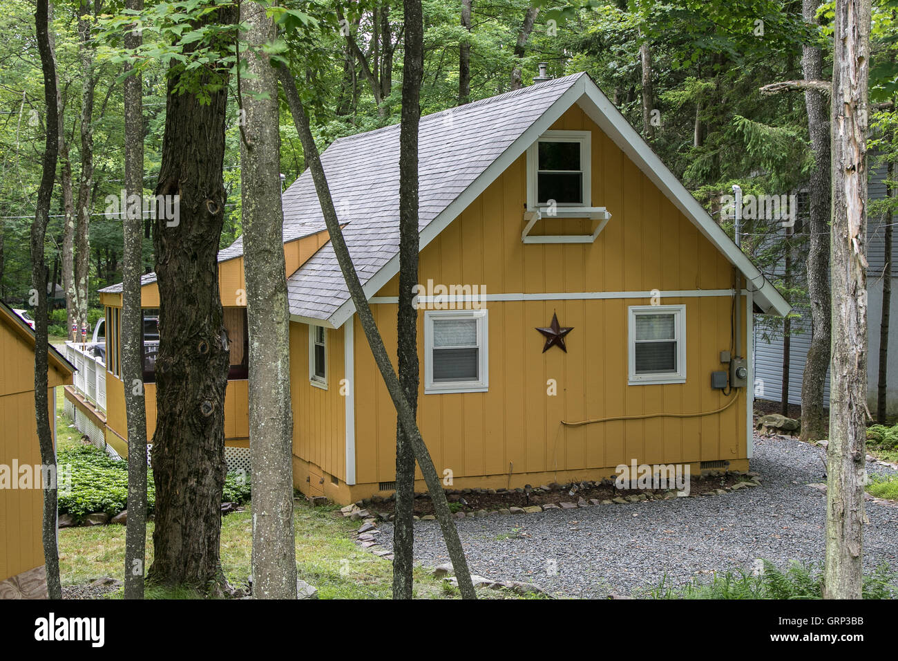 A Yellow Suburban House With A Decorative Brown Star Stock Photo