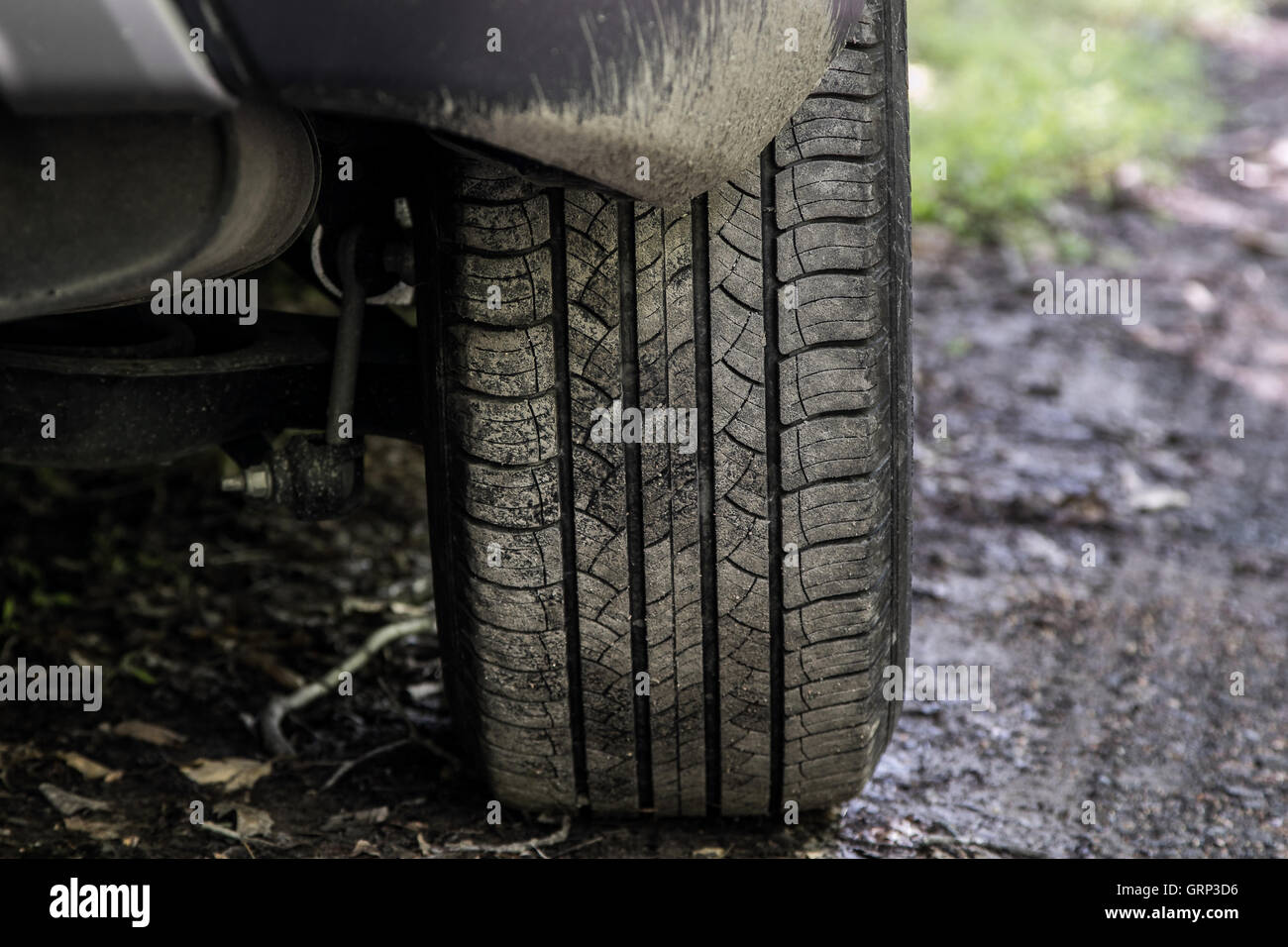 A closeup view of a car tire on an unpaved road. Stock Photo