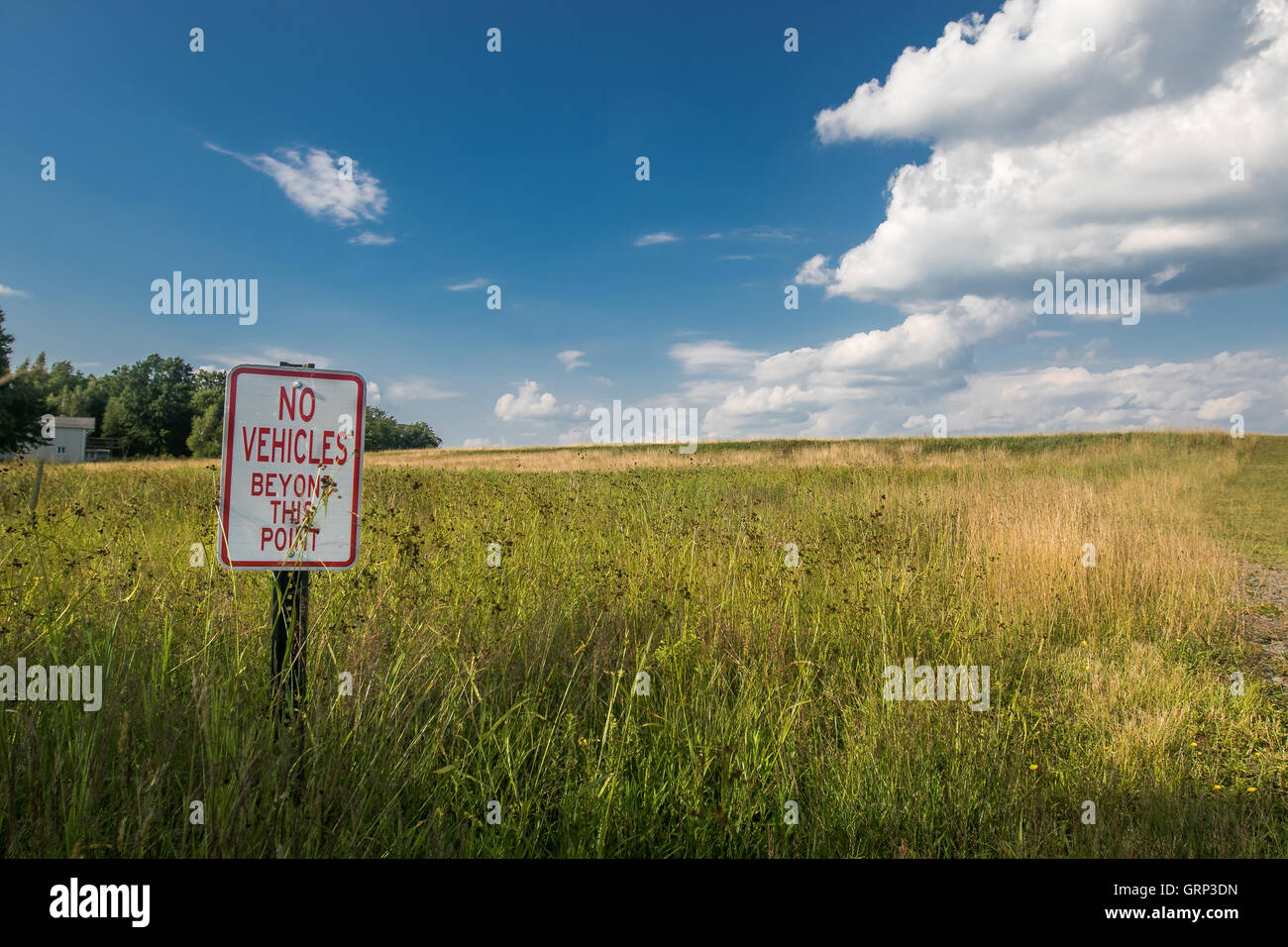 A 'No vehicles beyond this point' sign in a field. Stock Photo