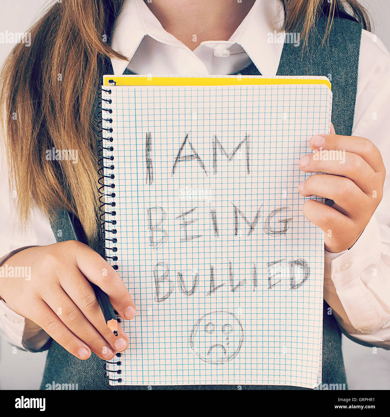 An image covering the Social Issues of child abuse,  schoolchild in uniform asking for help by a written message Stock Photo