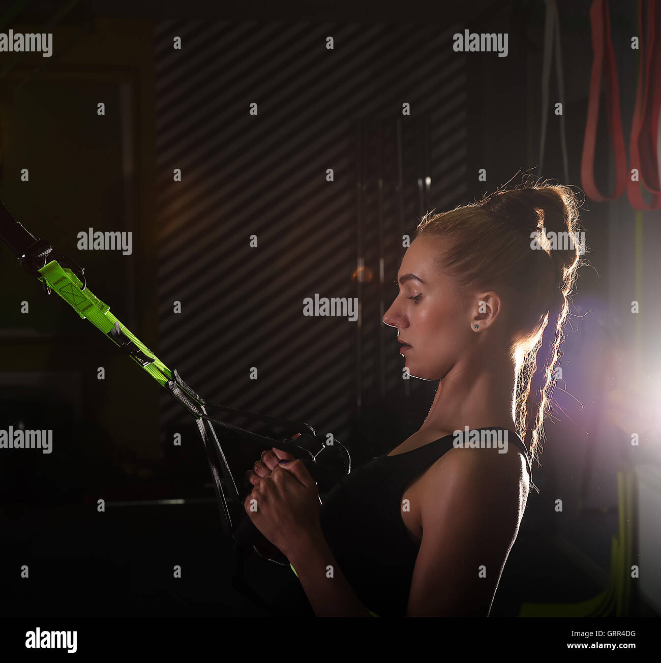 Women doing pull ups training arms with trx fitness straps in the gym ...