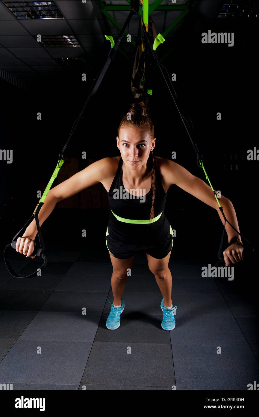 Women doing push ups training arms with trx fitness straps in the gym Concept workout healthy