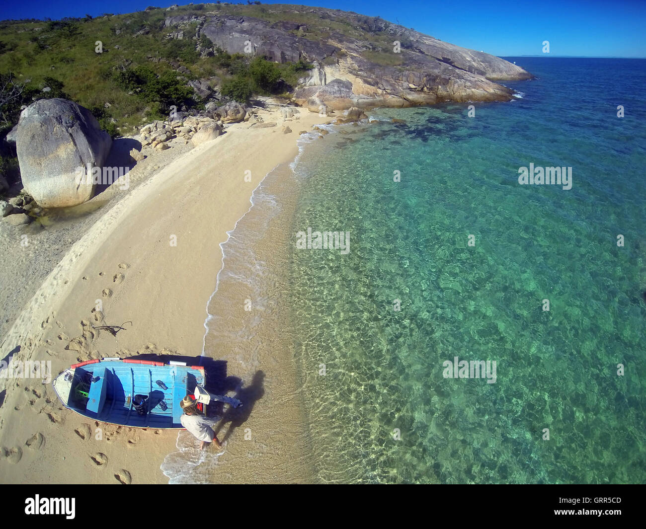 Aerial view of man with dinghy on beach at Turtle Bay, Lizard Island, Great Barrier Reef Marine Park, Queensland, Australia Stock Photo