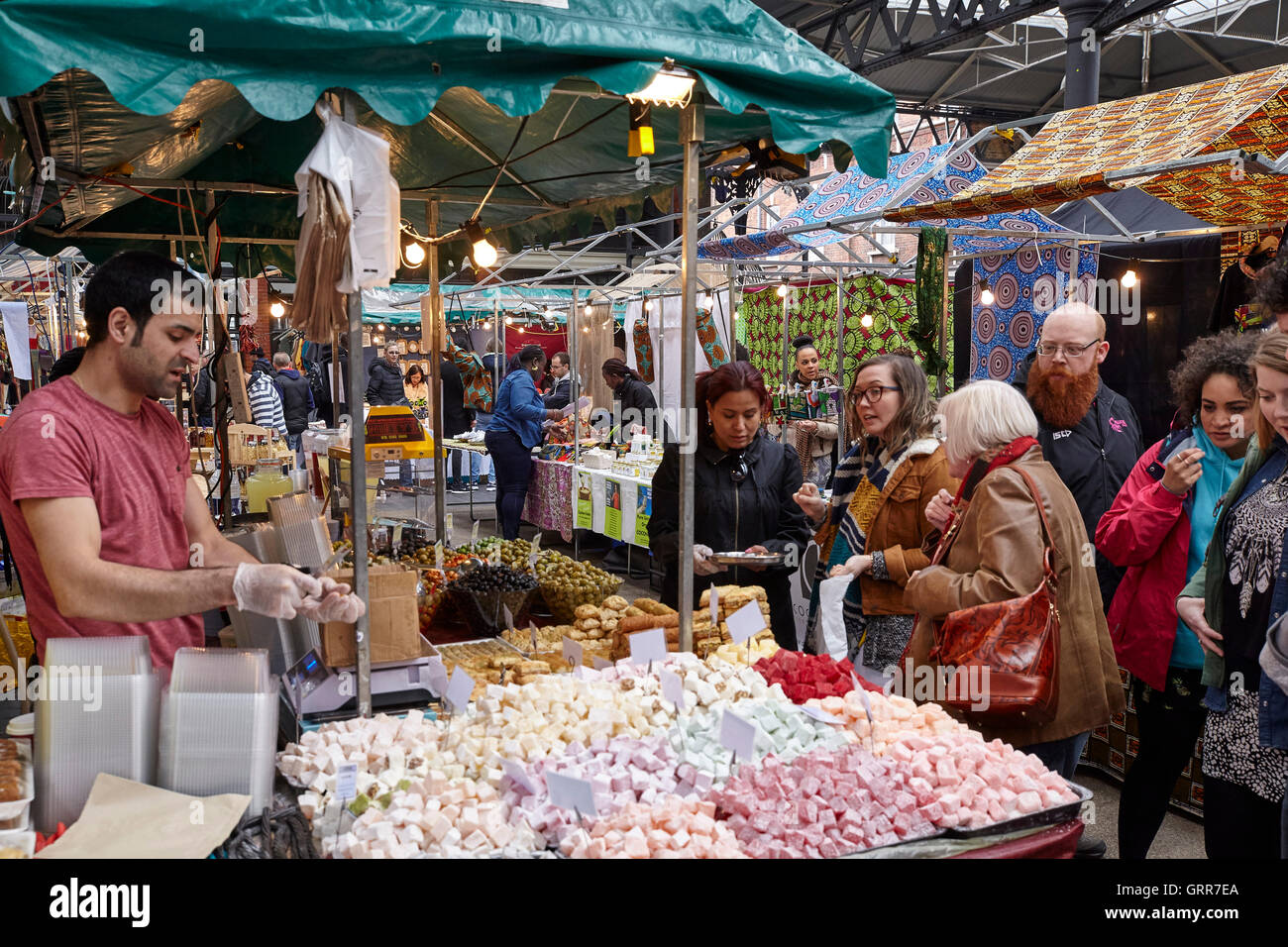 People shopping around the market and talking to the traders. Spitalfields Market, London, United Kingdom. Architect: Foster + Partners, 2005. Stock Photo