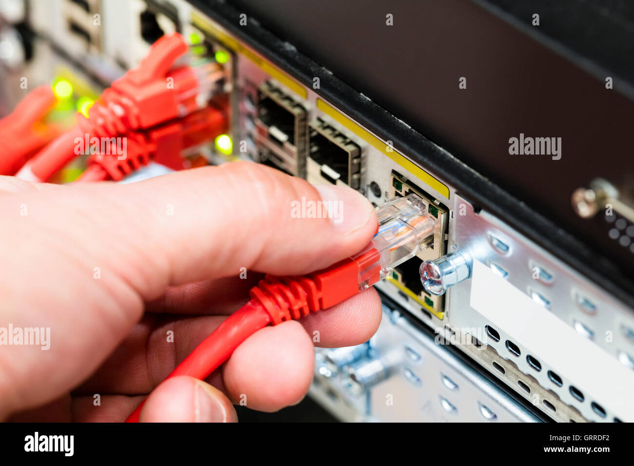 Hand Plugging Network Cable Into Switch In Datacenter Stock Photo Alamy