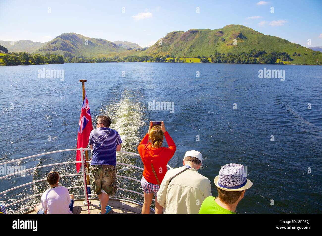 Tourists enjoying a cruise  and taking photographs aboard the stern of Ullswater Steamers. Ullswater, Penrith, The Lake District Stock Photo