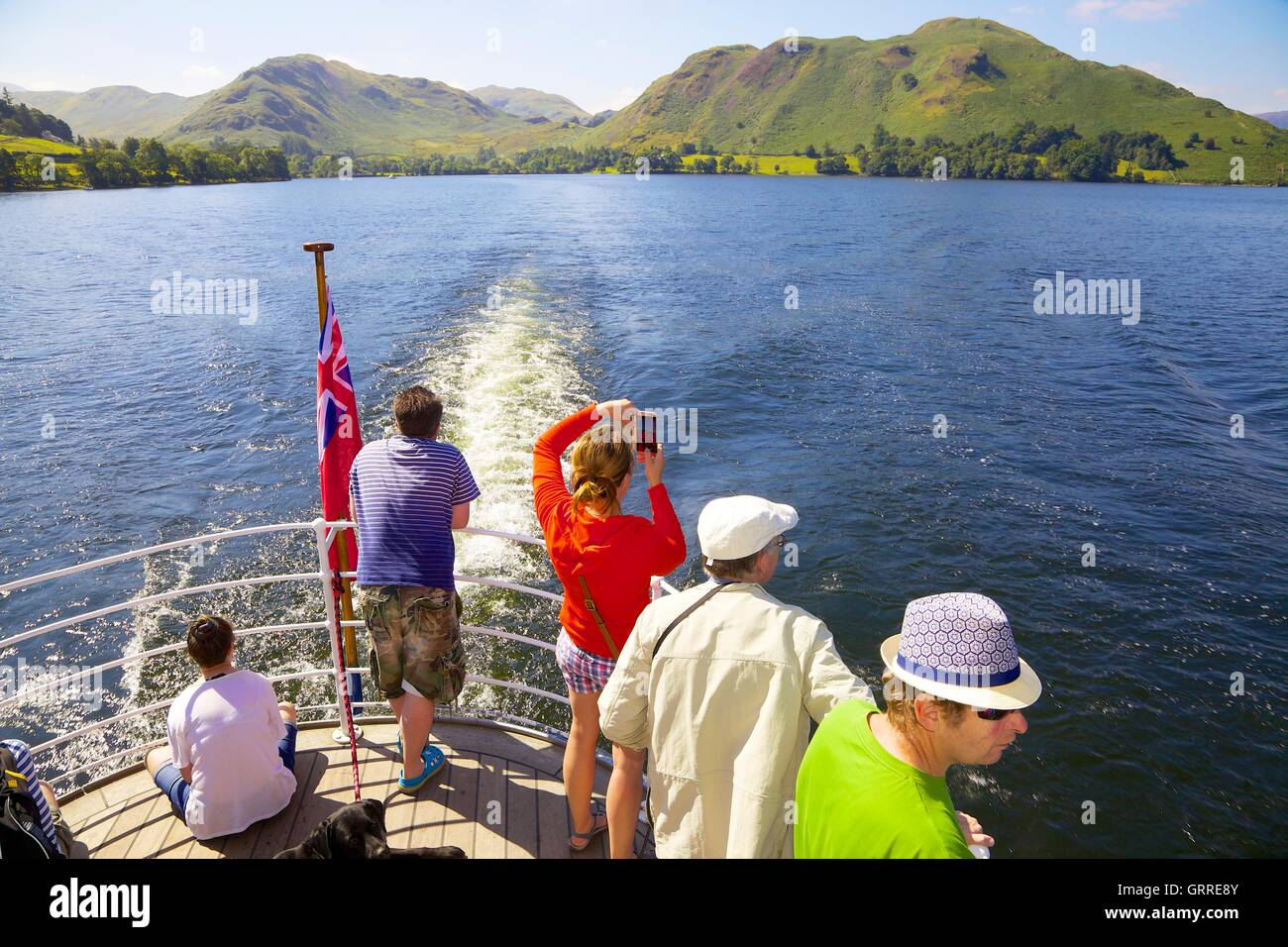Tourists enjoying a cruise  and taking photographs aboard the stern of Ullswater Steamers. Ullswater, Penrith, The Lake District Stock Photo