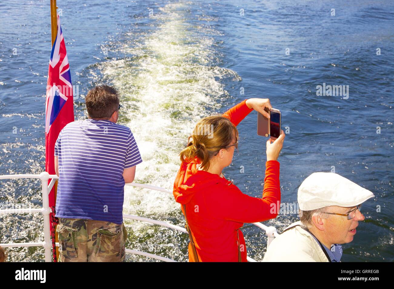 Tourists enjoying a cruise  and taking photographs aboard the stern of Ullswater Steamers  M.V Western Belle. Ullswater, Penrith Stock Photo