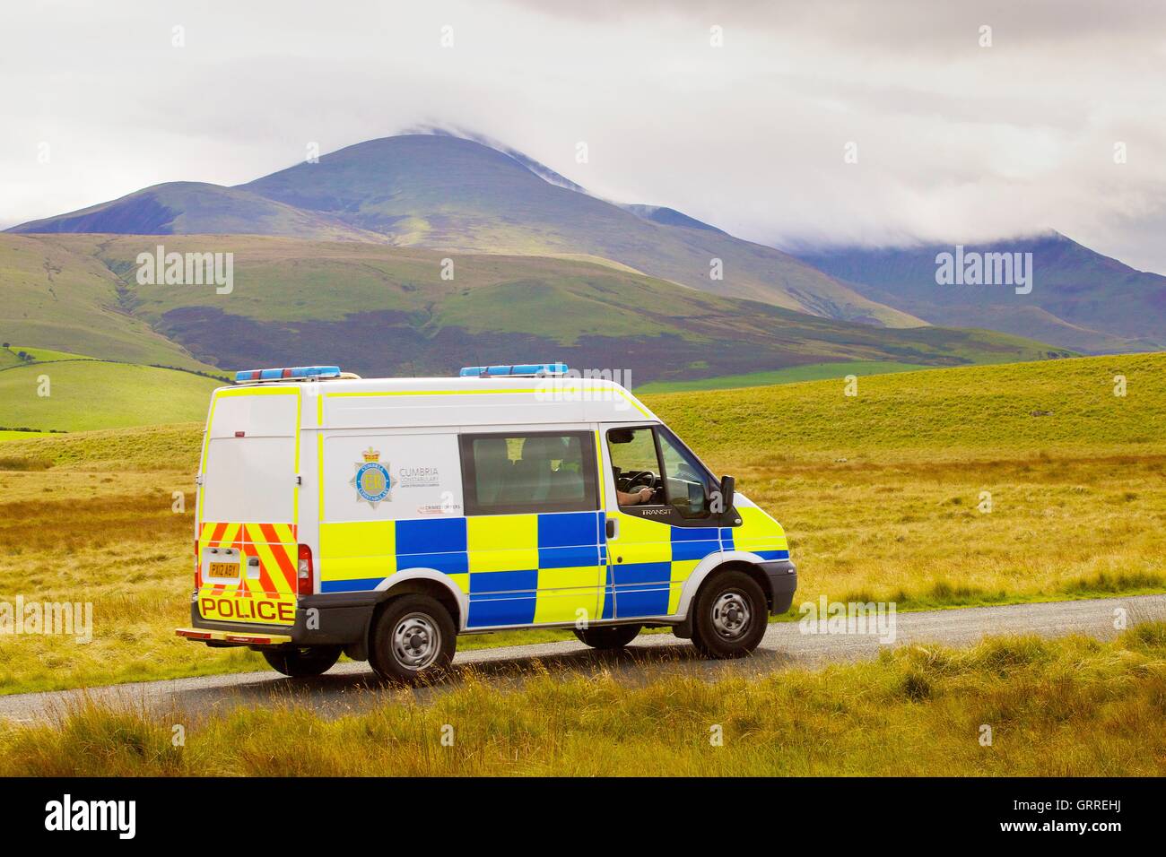 Police van on rural road. Aughertree Fell, Uldale, The Lake District National Park, Cumbria, England, United Kingdom, Europe. Stock Photo