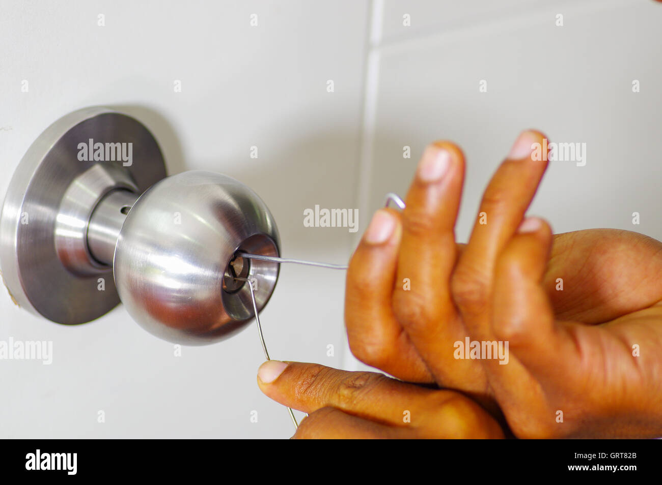 Closeup Hands Of Locksmith Using Pick Tools To Open Locked Door