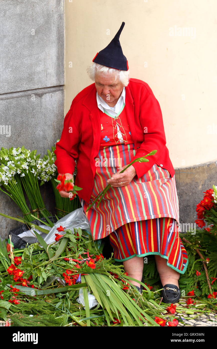 Woman in the traditional costume of Madeira selling flowers on the market in Funchal Stock Photo