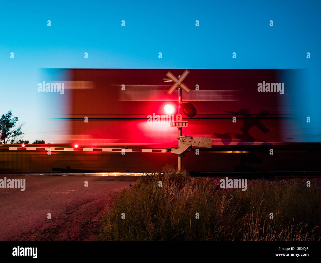 Freight by rail Canadian Pacific Railway speeding through a level crossing, Maple Creek, Saskatchewan, Canada. Stock Photo