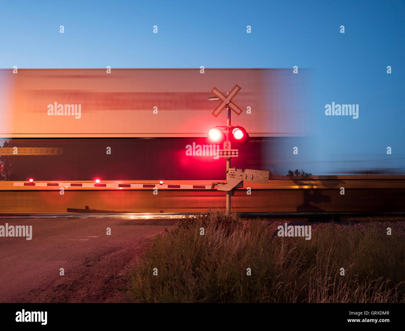 Freight by rail Canadian Pacific Railway speeding through a level crossing, Maple Creek, Saskatchewan, Canada. Stock Photo