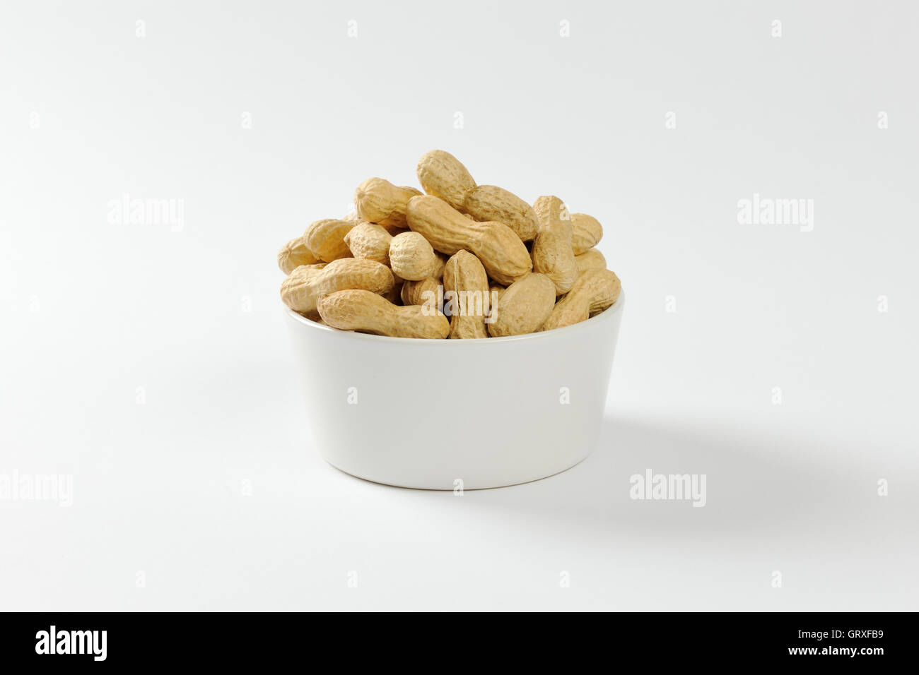 Bowl of raw unshelled peanuts Stock Photo