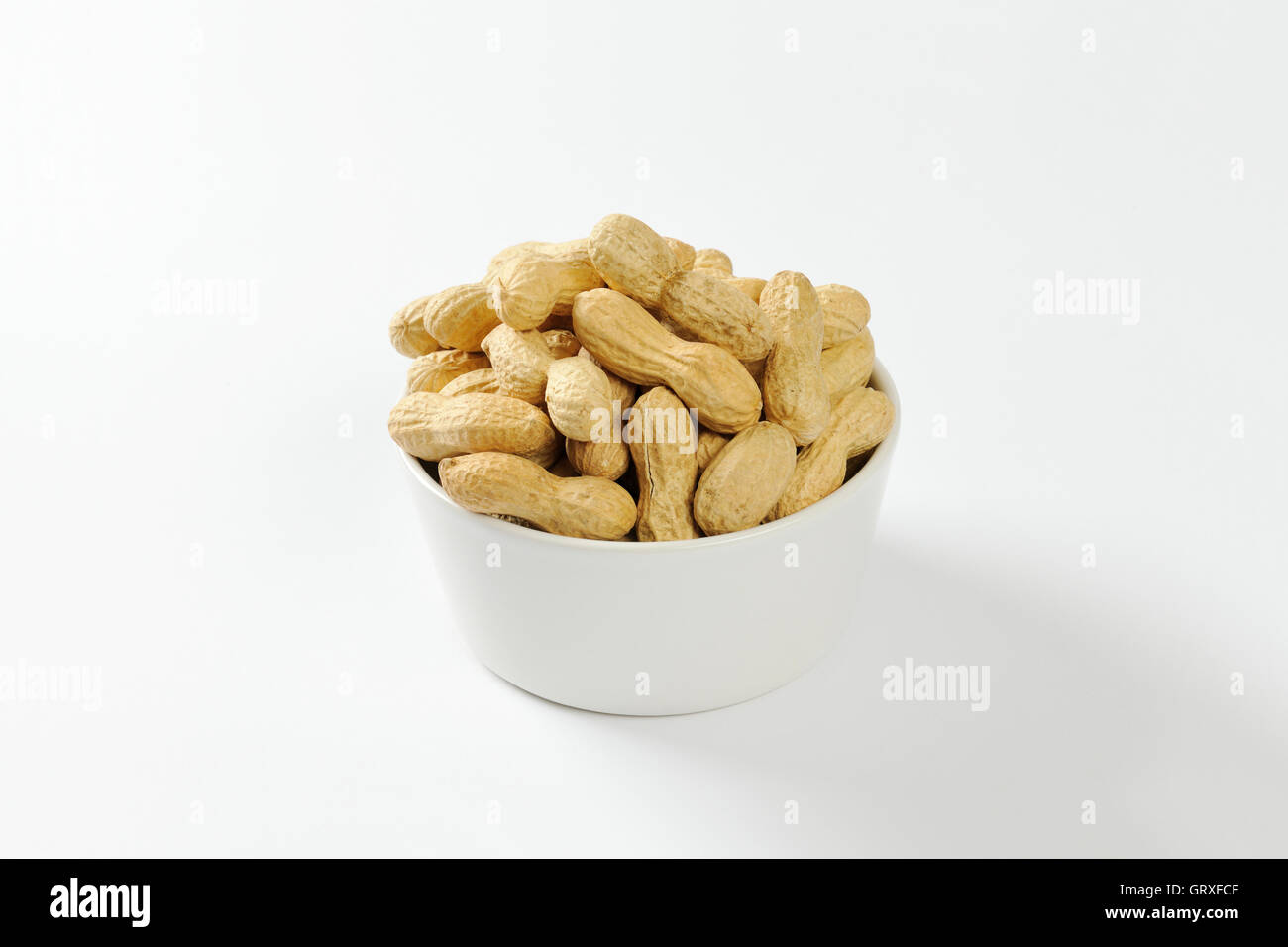 Bowl of raw unshelled peanuts Stock Photo
