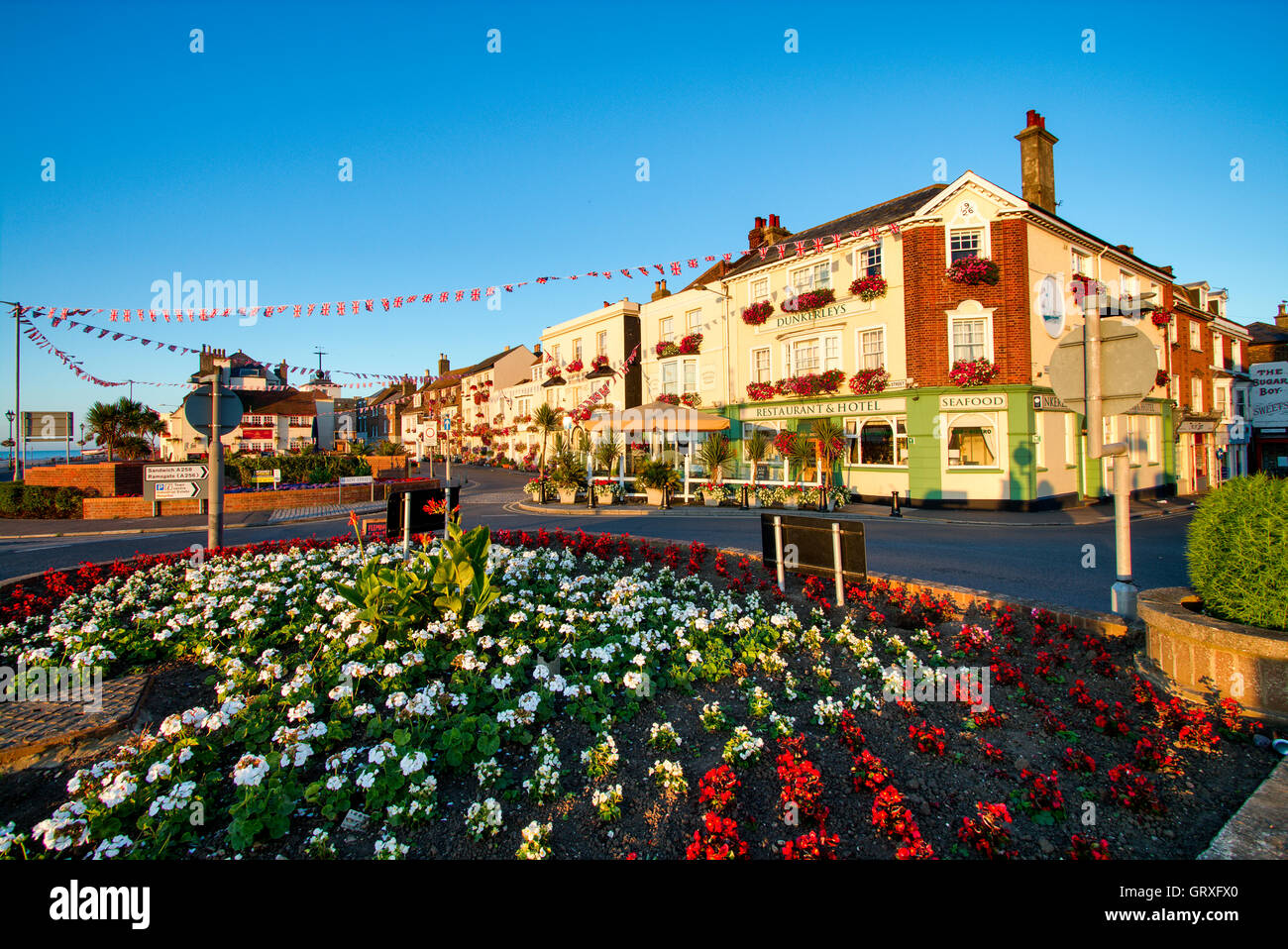 England, Deal. Flower display on roundabout in foreground, with Beach Street row of three story old buildings including Dunkerlays restaurant hotel. Stock Photo