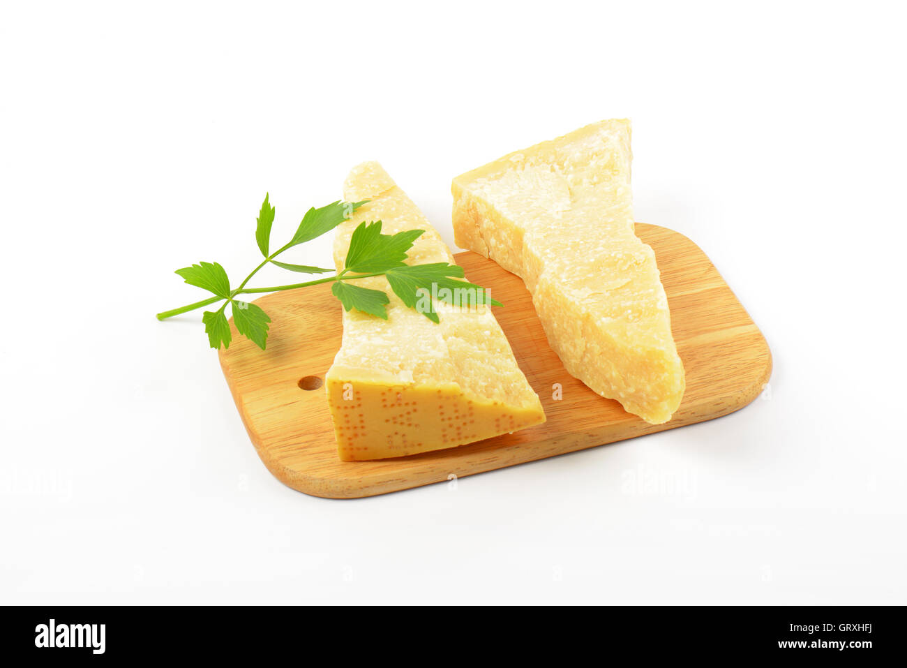 Two wedges of true Parmesan cheese on cutting board Stock Photo