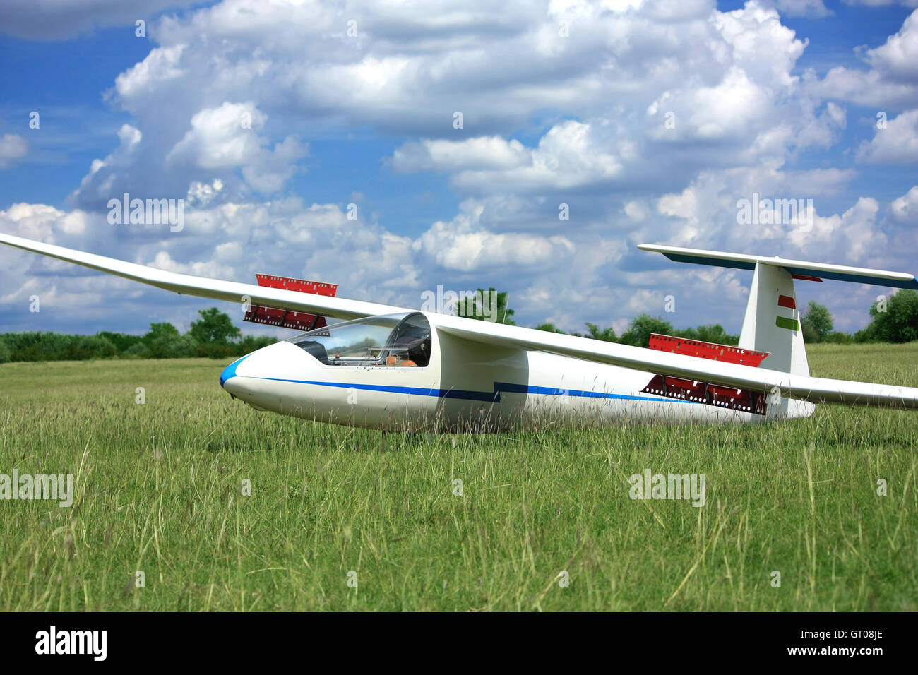 White glider airplane on runway grass with cloud sky Stock Photo Alamy