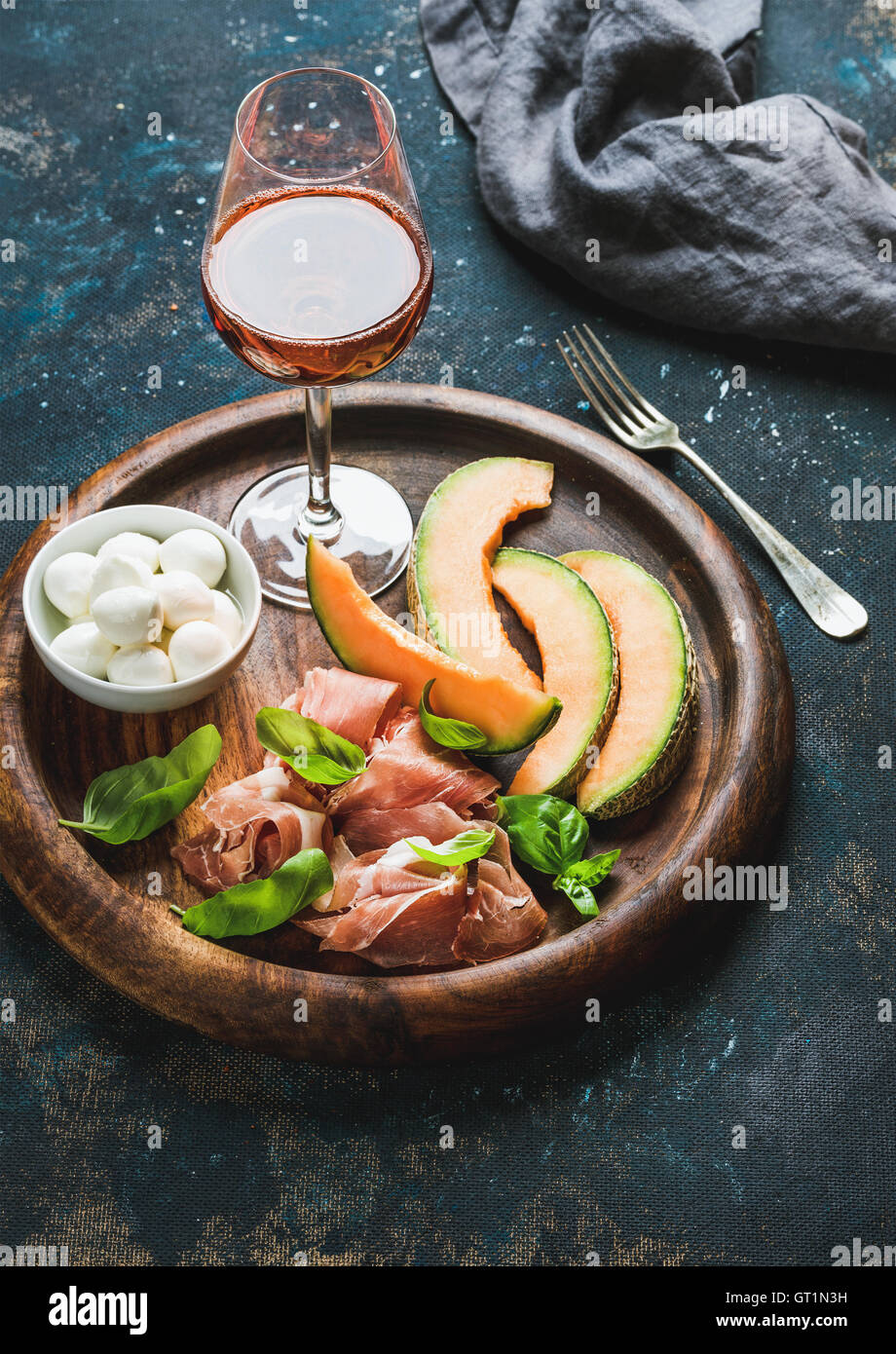 Prosciutto, cantaloupe melon, mozzarella cheese and glass of rose Stock