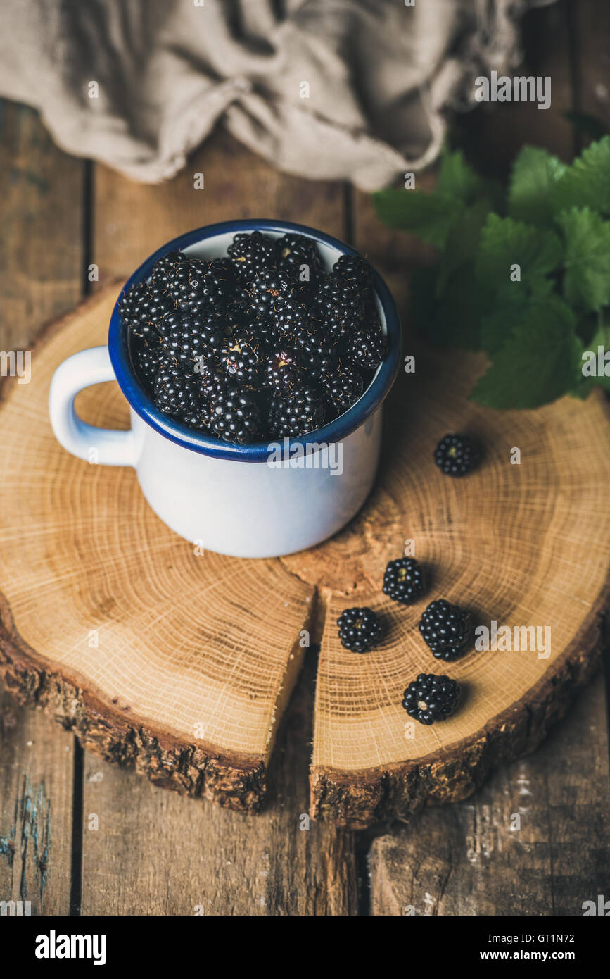 Fresh garden Blackberries in white cup on round serving wooden Stock Photo