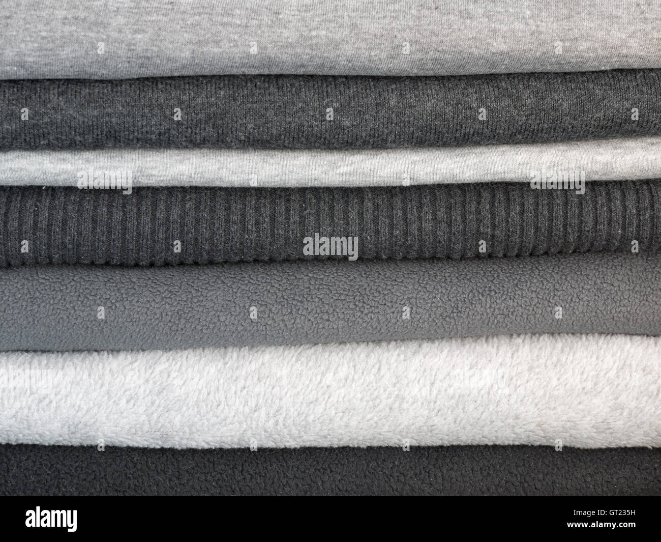 Stack of warm clothes in different shades of gray Stock Photo