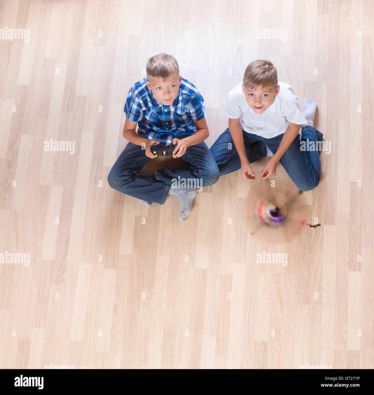 kids playing with flying helicopter model at home using remote control Stock Photo