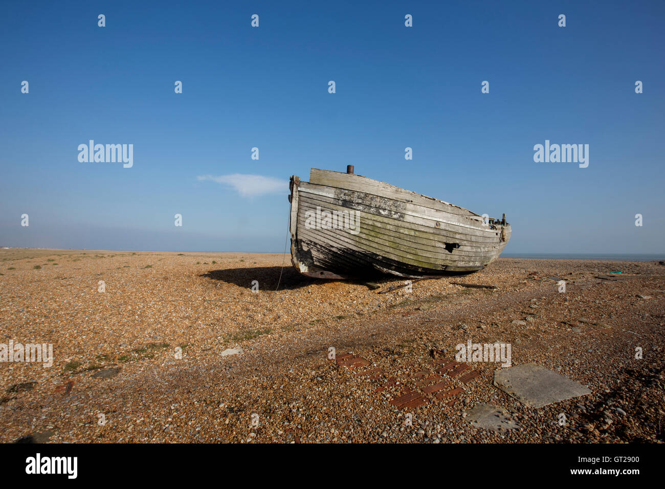 A derelict wooden fishing boat on a shingle beach Stock Photo - Alamy