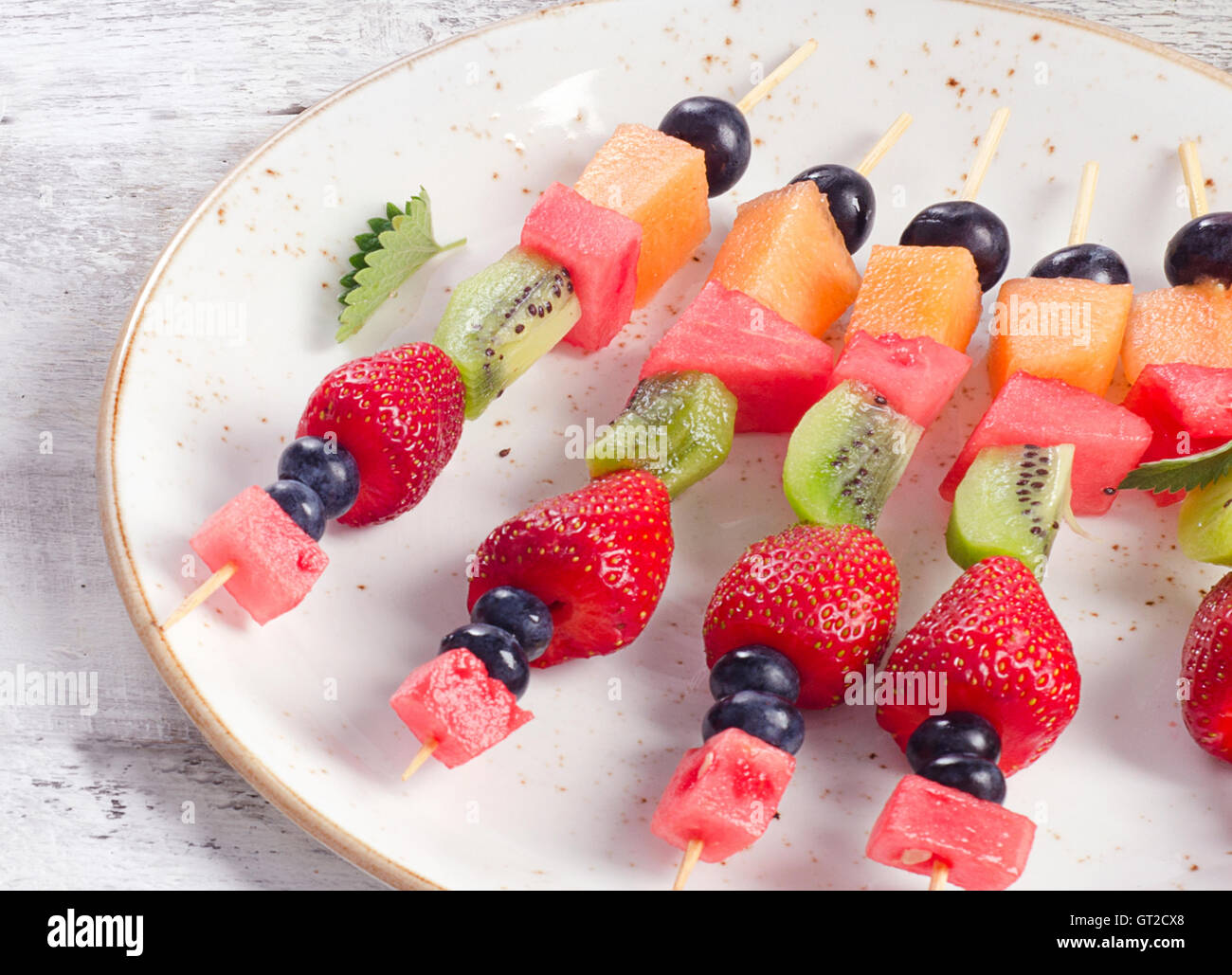 Colorful fruit kebabs on plate. Healthy eating Stock Photo Alamy