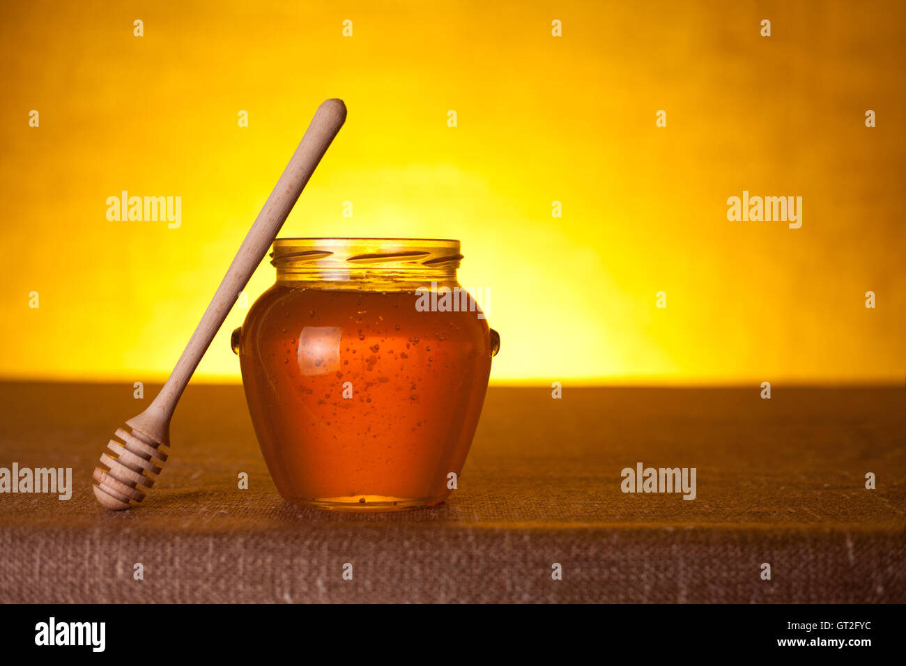 Glass honey jar with dipper Stock Photo Alamy