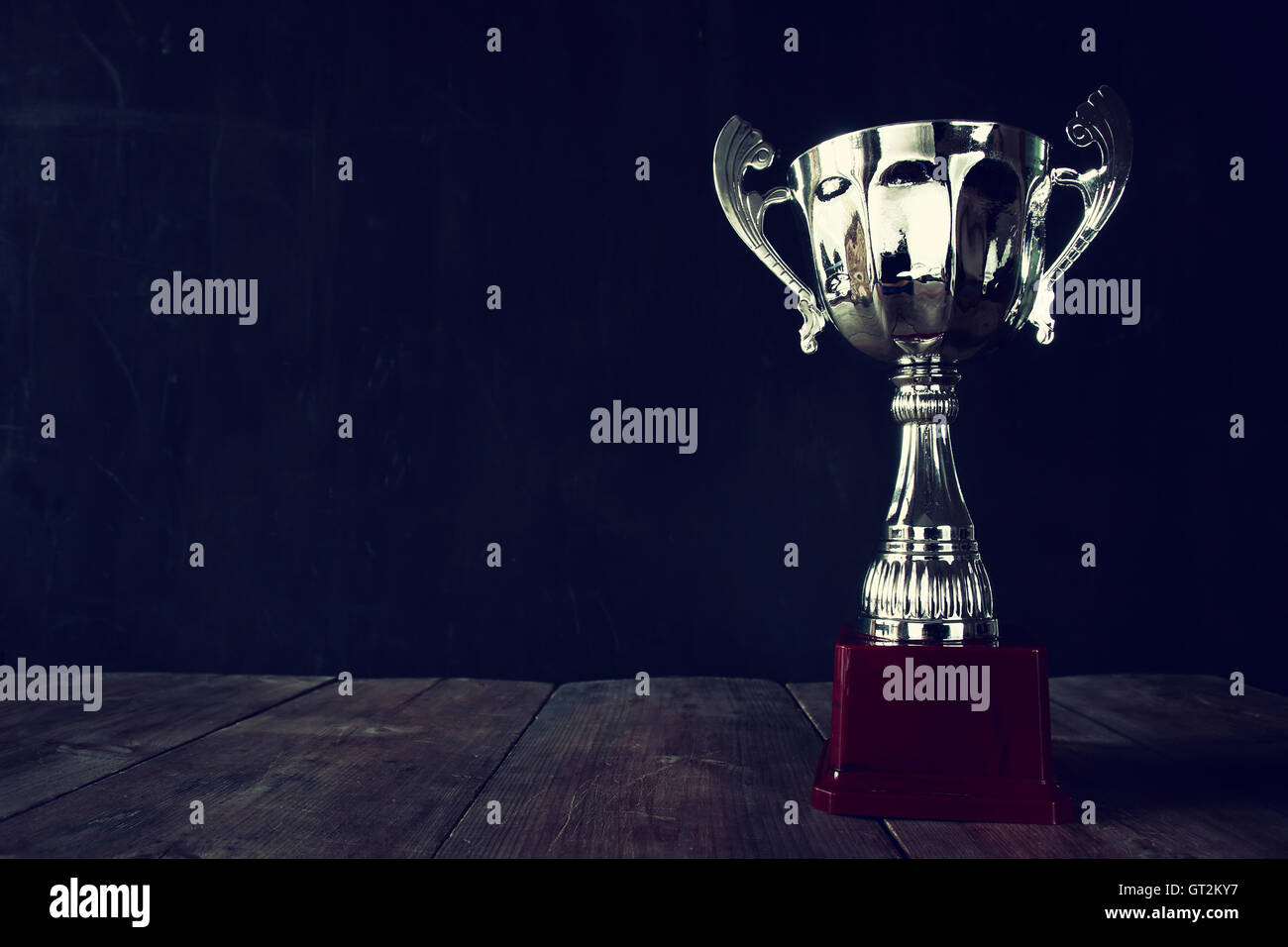low key image of trophy over wooden table and dark background Stock Photo -  Alamy