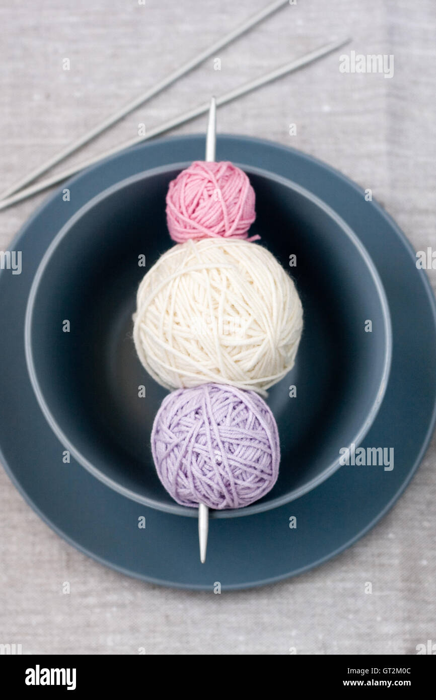 Bright balls of yarn and knitting needles on a plate Stock Photo - Alamy
