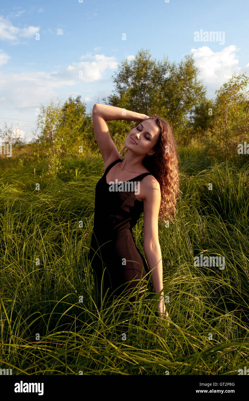 Beautiful girl walks in high grass Stock Photo - Alamy
