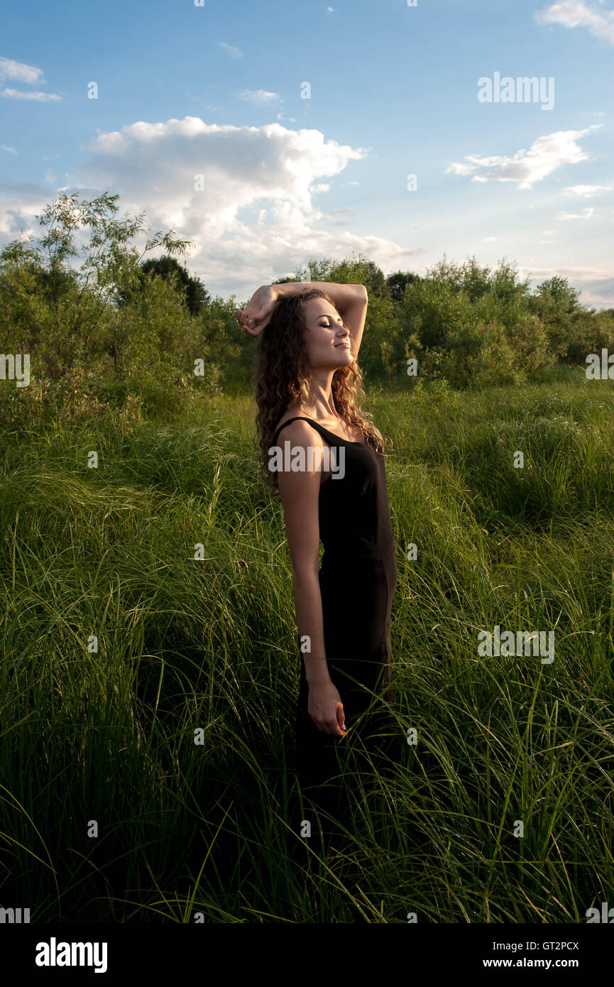 Beautiful girl walks in high grass Stock Photo - Alamy