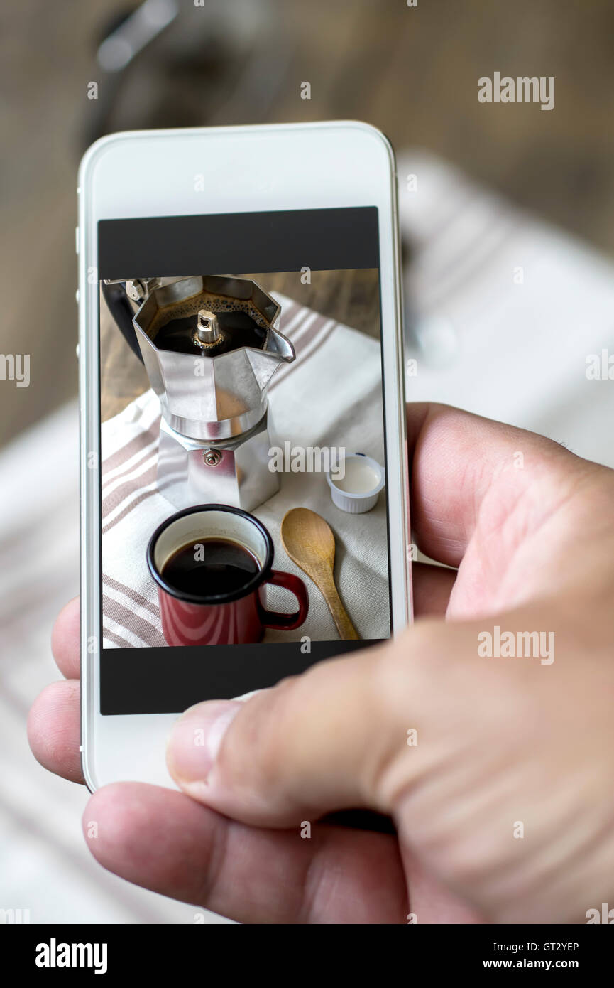 Hand of man taking photo of his cup of coffee. Close up Stock Photo