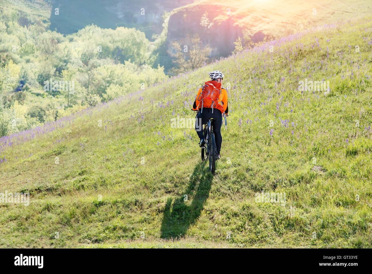 Young man traveler riding on bicycle with red backpack Stock Photo - Alamy