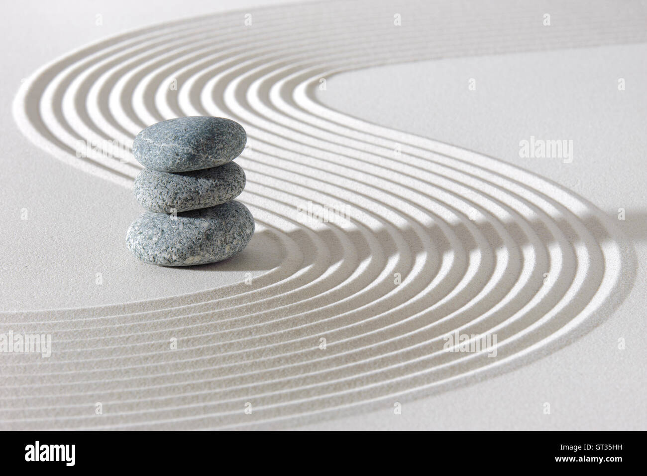 Japanese zen garden in white sand with stacked stones Stock Photo