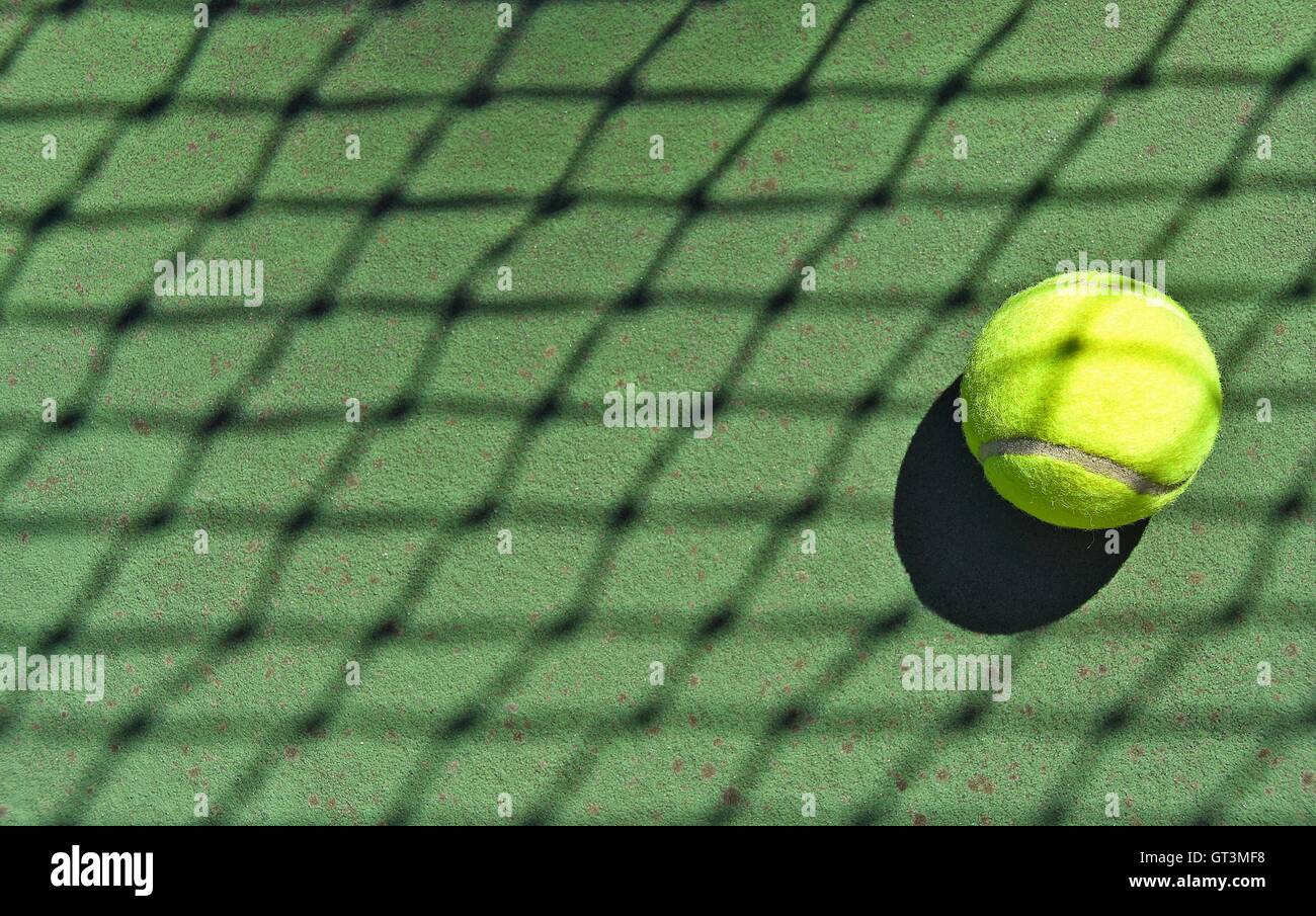 Crisscross net shadow on neon tennis ball. Stock Photo